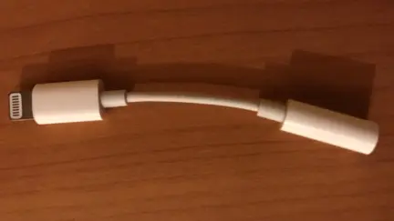Adaptador de Lightning a jack de 3,5 milímetros sobre una mesa de madera