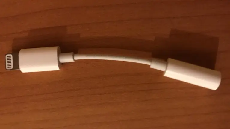 Adaptador de Lightning a jack de 3,5 milímetros sobre una mesa de madera